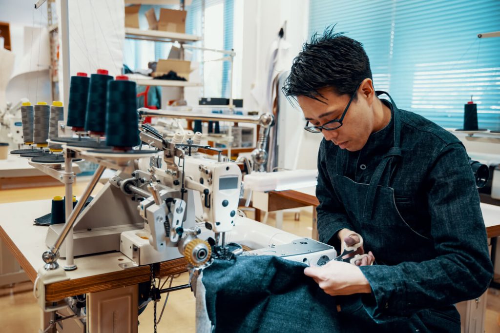 professional tailor working on alterations to dress pants