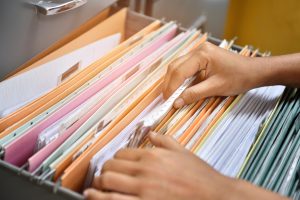 filing cabinet with different files and a person going through the files