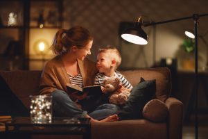 mom and son sitting on sofa couch reading evening