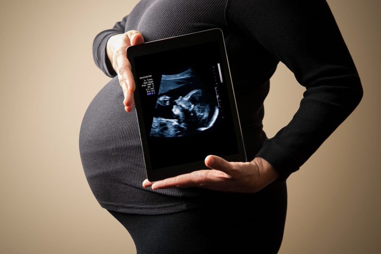 pregnancy woman holding an ipad ultrasound machine